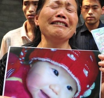 Baka drži sliku unuke za koju se vjeruje da je umrla od kontaminiranog mlijeka