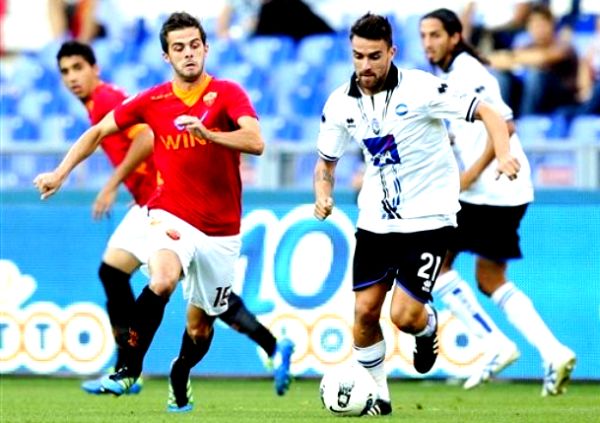 Miralem Pjanić u duelu s Lucom Cigarinijem; foto: AP