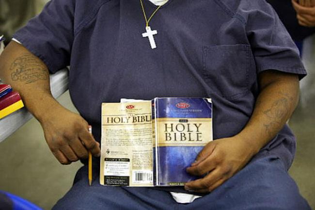 zatvorenik čita Bibliju